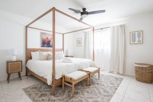 a bedroom with a canopy bed with a fan at Lighthouse Guest Suites in Fort Lauderdale