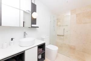 a bathroom with a toilet and a sink and a shower at Serenity at Solaris 101 in Forster