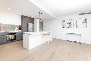 a kitchen with white cabinets and a white counter top at Serenity at Solaris 101 in Forster