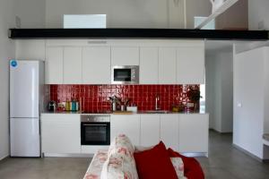 a kitchen with white cabinets and a couch in a room at El paller de L´Armentera 3 in Saldet