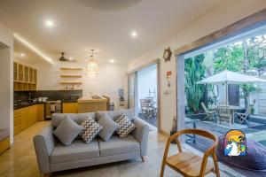 Il comprend un salon avec un canapé et une cuisine. dans l'établissement Hurley House - by Unicorn Villas Bali, à Canggu