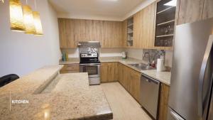a kitchen with wooden cabinets and a stainless steel appliance at Tumon Isa 16 Condo in Tamuning