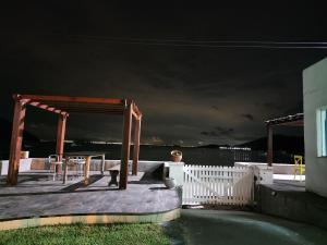 - Vistas nocturnas a una terraza con una valla blanca en Casa Grega, en Governador Celso Ramos