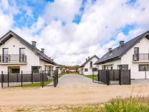 a row of white houses with a fence at Comfortable holiday complex in Jastrzebia Gora in Jastrzębia Góra