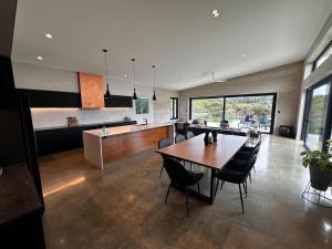 a dining room and kitchen with a table and chairs at INDICA HEMP HOUSE - Multi Award Winning-Luxury-Eco designed house-lake views-hot tub-Cinema in Wilyabrup