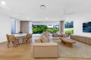 ein Wohnzimmer mit Möbeln und einem Tisch in der Unterkunft Beachside, luxury resort living in Yaroomba
