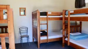 a room with three bunk beds and a chair at Lakes Edge Lodge in Lake Tekapo