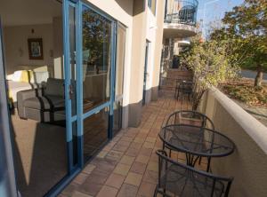 a patio with two chairs and tables on a balcony at Panorama Motor Lodge in Timaru
