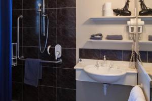 a bathroom with a shower and a sink and a phone at Panorama Motor Lodge in Timaru