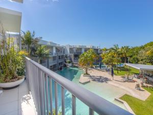 a balcony with a view of the pool and the beach at Drift North Beachfront Apartments - Private Apartments in Kingscliff