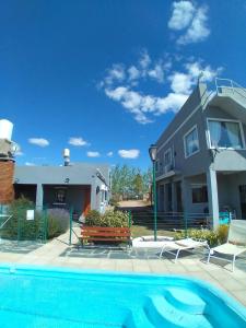 una casa y una piscina frente a una casa en Cabañas la bonita en Trapiche