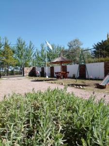 un parque con una mesa de picnic y una cometa blanca en Cabañas la bonita en Trapiche