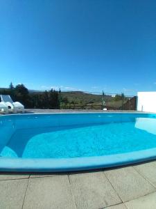 una gran piscina azul con un cielo azul en el fondo en Cabañas la bonita en Trapiche