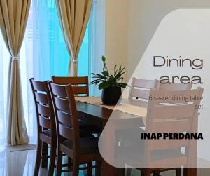 宋溪的住宿－Inap Perdana Sungkai, Perak，用餐区配有玻璃桌和椅子