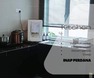 a kitchen with a sink and a counter with a microwave at Inap Perdana Sungkai, Perak in Sungkai