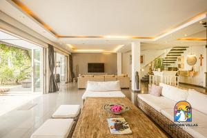 uma sala de estar com um sofá e uma mesa em Villa Black Pearl - by Unicorn Villas Bali em Padangbai