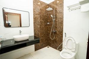 a bathroom with a toilet and a sink and a shower at Hotel Trung Duong in Móng Cái