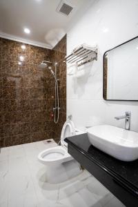 ein Bad mit einem Waschbecken, einem WC und einer Dusche in der Unterkunft Hotel Trung Duong in Móng Cái