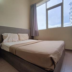 a bedroom with a large bed with a window at Park City Motel in Melaka