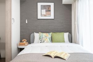 una camera da letto con un letto con un libro sopra di ZAITO Kikukawa SRS Apartment 新築マンション a Tokyo