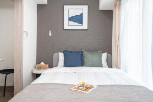 una camera da letto con un grande letto bianco con cuscini blu di ZAITO Kikukawa SRS Apartment 新築マンション a Tokyo