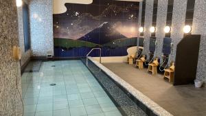 a swimming pool in a restaurant with a mural on the wall at hotel MONday Premium TOYOSU in Tokyo