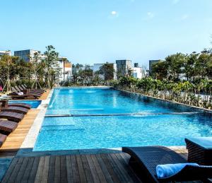 una grande piscina con sedie e acqua blu di Jeju Breeze a Seogwipo