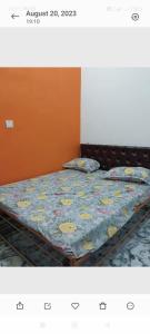uma cama com uma colcha e almofadas em Laxman Guest House em Varanasi