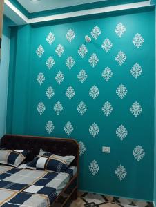 a bedroom with a blue wall with snowflake wallpaper at Laxman Guest House in Varanasi