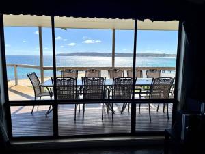 een tafel en stoelen op een balkon met uitzicht op de oceaan bij House of the Young - Emu Bay in Emu Bay