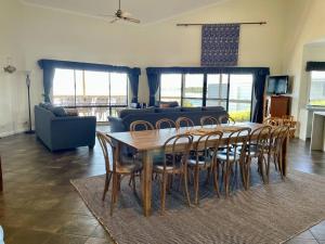 a living room with a wooden table and chairs at House of the Young - Emu Bay in Emu Bay