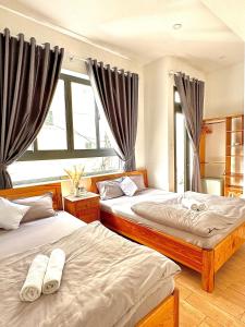 a bedroom with two beds and a window at Khoảng Lặng ATP in Da Lat