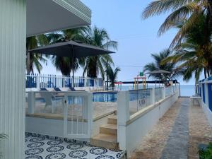 a balcony with a table and an umbrella on the beach at Hotel Playarena in Coveñas