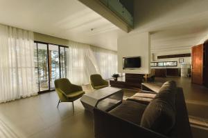 a living room with a couch and chairs and a tv at Terracotta Hotel & Resort Dalat in Da Lat