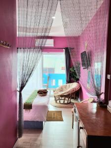 Schlafzimmer mit rosa Wänden, einem Bett und einem Fenster in der Unterkunft บ้านเนวี่ เกาะล้าน in Ko Larn