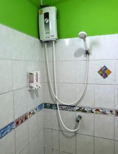 a shower with a hose in a bathroom at บ้านเนวี่ เกาะล้าน in Ko Larn