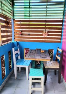 una mesa y sillas frente a una habitación con ventana en บ้านเนวี่ เกาะล้าน, en Koh Larn