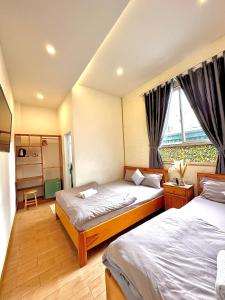 um quarto com 2 camas e uma janela em Khoảng Lặng ATP em Da Lat