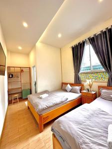 a bedroom with two beds and a window at Khoảng Lặng ATP in Da Lat