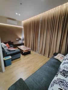 a living room with two beds and a couch at Summer Mall Summer Suite 2 bedroom unit in Kota Samarahan