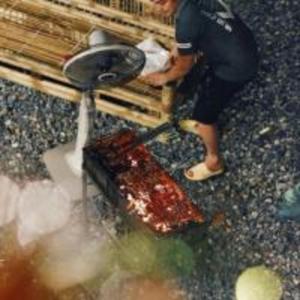 una persona está lavando un pedazo de carne en una mesa en Giang House en Hòa Bình
