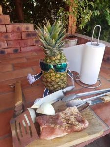 a table with a pineapple and a slice of pizza at Dura Vendégház in Paszab