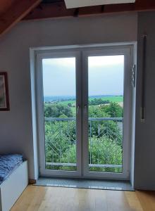 um quarto com uma porta de vidro deslizante e vista em Panorama-Suite Birkenbeul em Birkenbeul