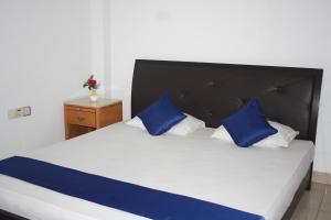 Una cama con almohadas azules y blancas. en kandywin Hotels, en Kandy