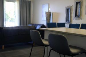 uma sala de espera com cadeiras azuis e uma mesa em Zorba Waterfront Motel em Batemans Bay