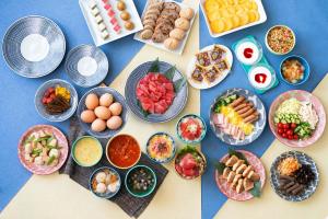 uma mesa com tigelas de comida e pratos de comida em Vessel Inn Yachiyo Katsudai Ekimae em Yachiyo