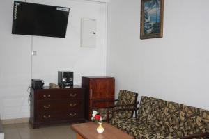 sala de estar con sofá, mesa y TV en kandywin Hotels, en Kandy