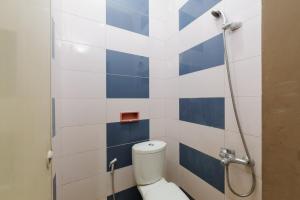 ein Badezimmer mit einem WC mit blauen und weißen Fliesen in der Unterkunft RedDoorz near The Jungle Waterpark Bogor in Bogor + 24 Fotos