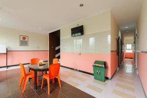 a dining room with a table and chairs and a trash can at RedDoorz near The Jungle Waterpark Bogor in Bogor