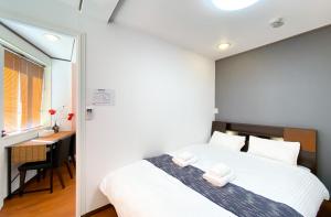 a bedroom with a white bed and a desk at Uhome Mitomi Home 3F in Tokyo